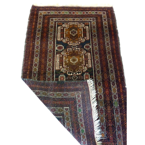 1282 - A Turkoman style rug with multiple red borders around two geometric medallions 185 x 118cm