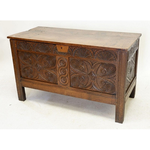 1284 - An 18th century oak coffer with incised decoration to front panels and frieze, 123cm wide