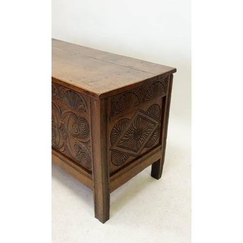 1284 - An 18th century oak coffer with incised decoration to front panels and frieze, 123cm wide