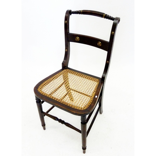 1292 - An early 19th century ebonised and cane seated chair with brass stud decoration