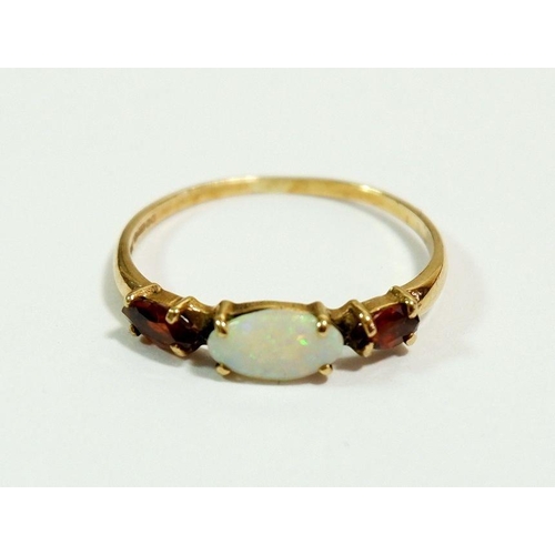 617 - A 9 carat gold ring set opal flanked by two garnets, size N to O, 1.1g