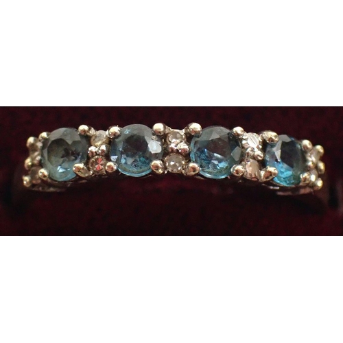 607 - A 9 carat gold ring line set blue topaz and pair of chip diamonds, size O