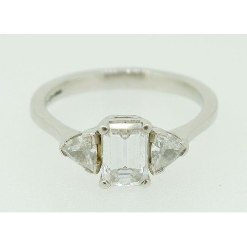 243 - A fine platinum ring set central emerald cut diamond flanked by two trilliant cut diamonds, size N, ... 