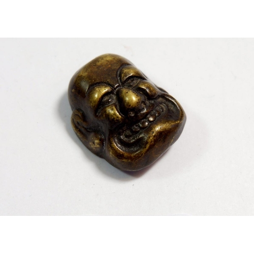 614 - A Japanese bronze finish miniature mask, 3.5 x 3cm