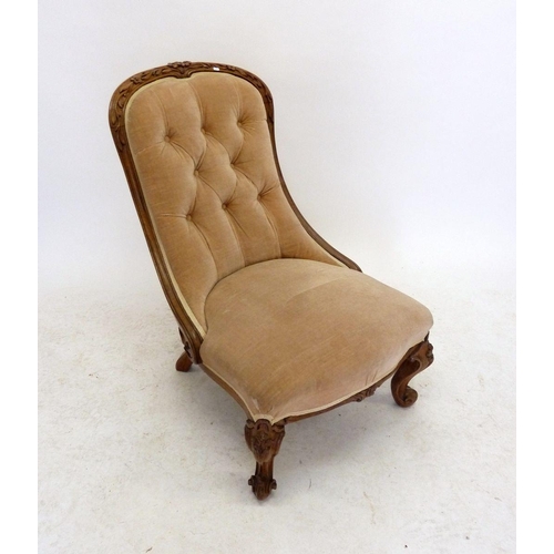 1132 - A Victorian rosewood framed nursing chair with floral carved rail and button upholstered back