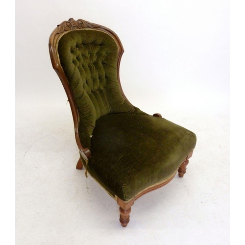 1133 - A Victorian green upholstered button back nursing chair with carved floral top rail