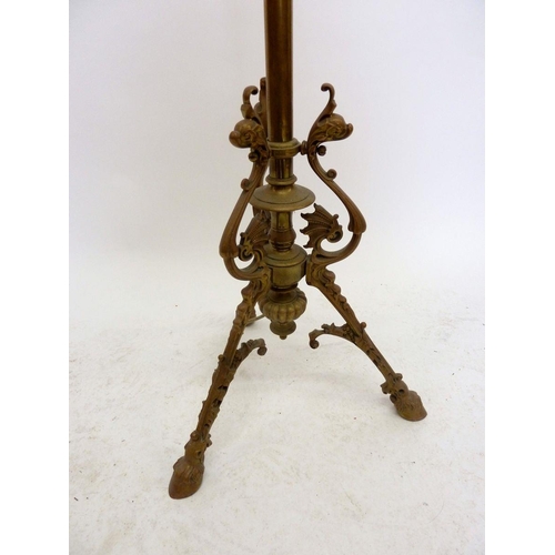 1145 - A 19th century brass extending standard lamp base with scrollwork and triple hoof feet