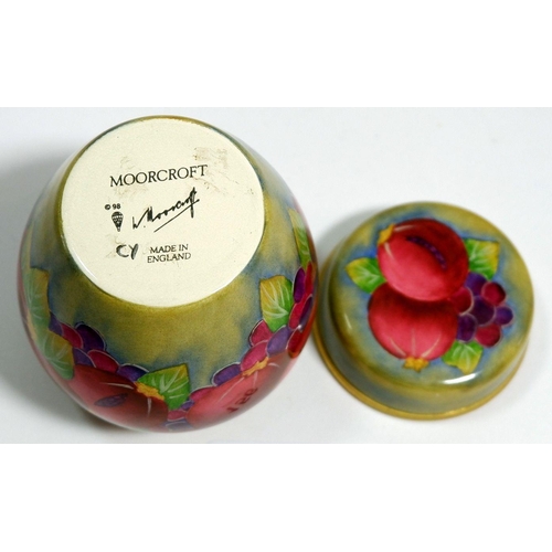 156 - A Moorcroft enamel miniature ginger jar and cover painted pomegranate on a green ground, 7cm