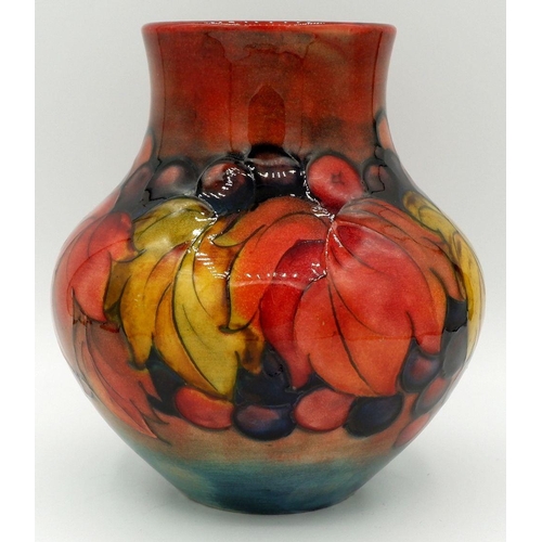 162 - A Moorcroft vase in the leaves and fruit design with William Moorcroft monogram, 21cm tall