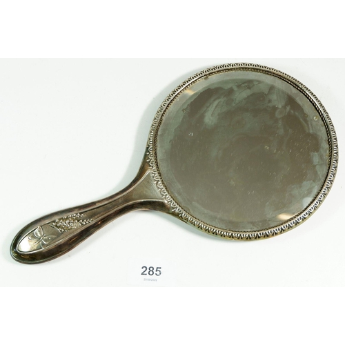 285 - A silver hand mirror with embossed butterflies and flowers