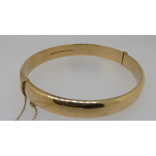 291 - A 9ct gold hinged bangle with engraved decoration, 10g