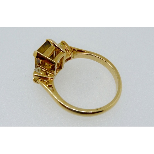 363 - An 18 carat gold ring set green/brown stone flanked by two diamonds, size K, 4.3g