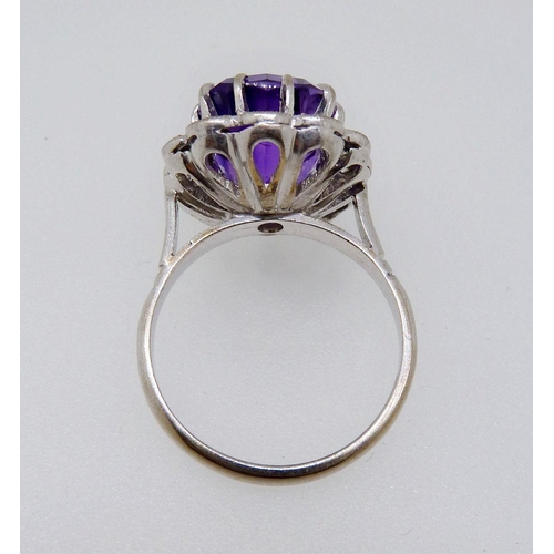 373 - An 18 carat gold ring set cushion cut amethyst within diamond surround, size K-L, 6.4g