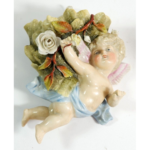 72 - A novelty continental porcelain nodding head cowboy and a Victorian cherub wall pocket