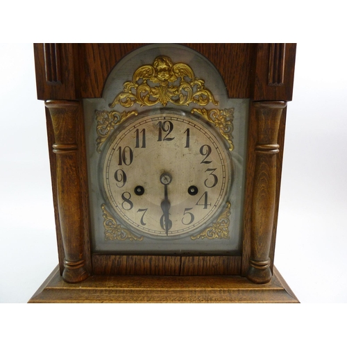 777 - An oak mantel clock with gilt spandrels and silvered dial, 36cm tall