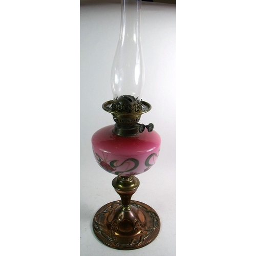 920 - An Edwardian copper Art Nouveau oil lamp with painted pink glass reservoir and a brass oil lamp with... 