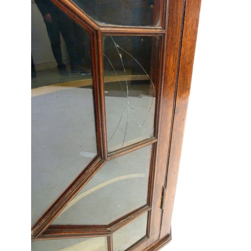 940 - A George III oak astragal glazed corner cupboard with serpentine drawers, 92cm tall