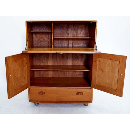 1033 - An Ercol light elm cabinet with drop front over cupboard and drawer, Height 110cm, Width 83cm and De... 