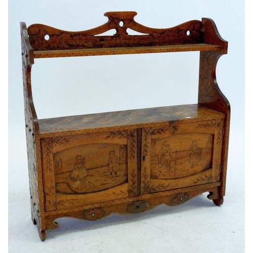 1043 - An Edwardian wall shelf and cupboard with all over inlaid decoration of Dutch children, flowers and ... 