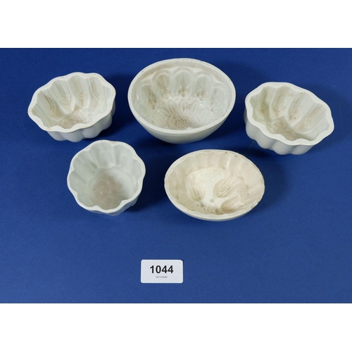 1044 - A collection of four miniature pottery jelly moulds, largest 10cm wide and a Shelley one