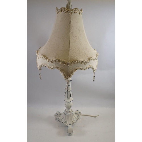 1207 - A white painted table lamp on scrollwork base, 79cm tall