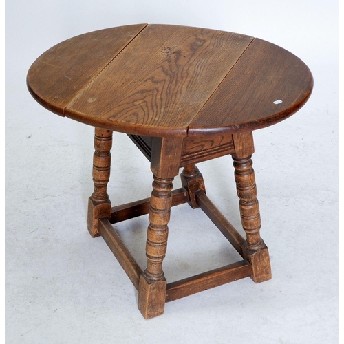 1215 - An oak dropleaf swivel top occasional table