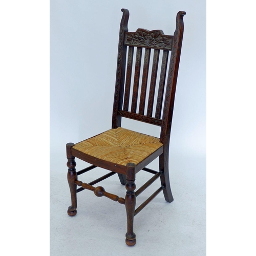 1243 - A slat back rush seated chair with carved decoration