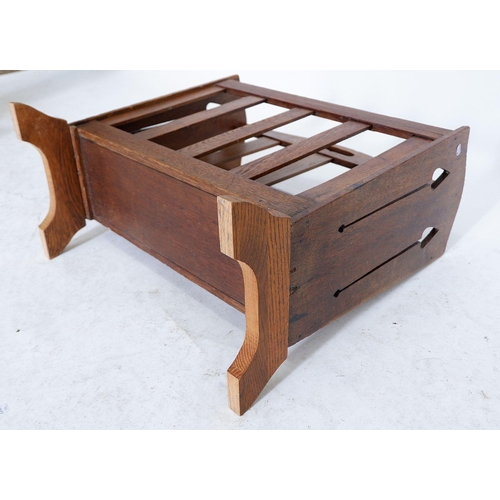 1254 - A Liberty oak magazine rack with pierced tulip cut outs to ends, replacement base 49cm