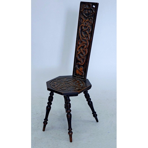 1259 - A Victorian carved oak spinning chair with intertwined beasts to back, dated 1895