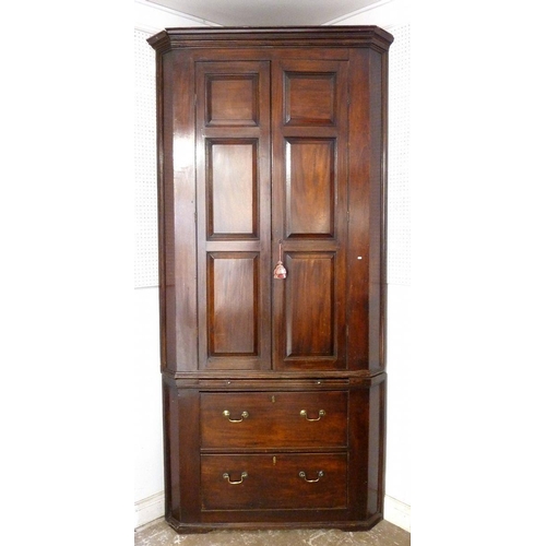 1262 - A Georgian large mahogany corner cupboard with panelled doors enclosing shelves over pull out slide ... 