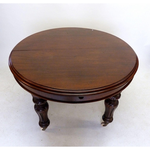 1289 - A Victorian mahogany oval dining table with two interleaves on carved supports and castors, approx. ... 