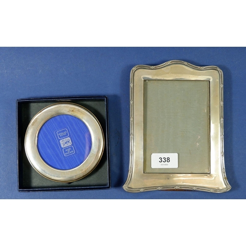 338 - A silver photograph frame, Birmingham 1921, by William Neale & Son Ltd, and a circular frame boxed, ... 