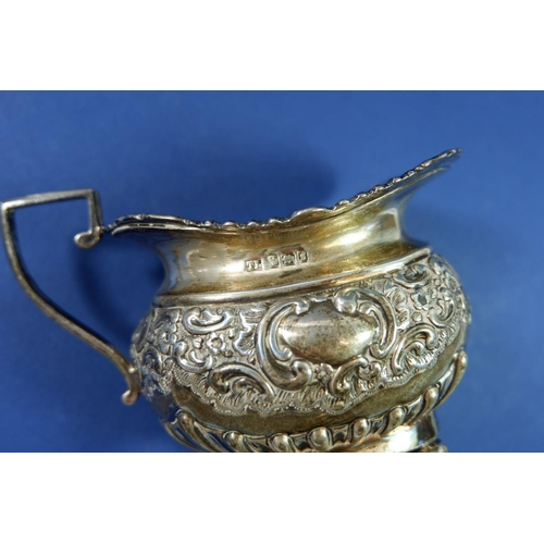 404 - A silver jug with embossed decoration, Sheffield 1910, 126g