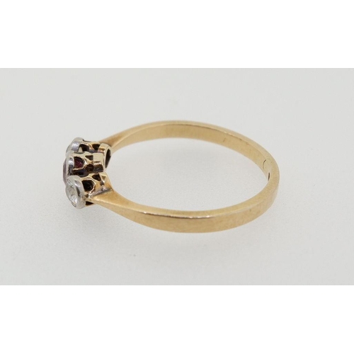 426 - An 18 carat gold ring set red stone flanked by two diamonds, size L-M, total weight 2g