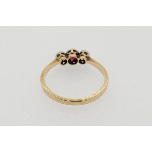 426 - An 18 carat gold ring set red stone flanked by two diamonds, size L-M, total weight 2g