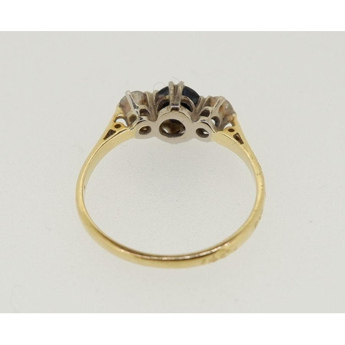 442 - An 18 carat gold ring set sapphire flanked by two diamonds, 2.4g, size N