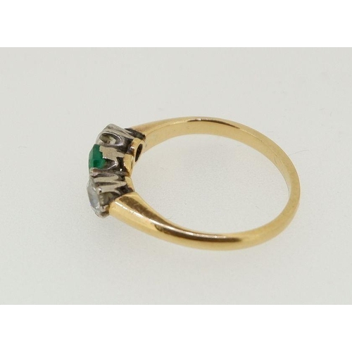 446 - A 18 carat gold ring set emerald flanked by two diamonds (each .4cts each), size O