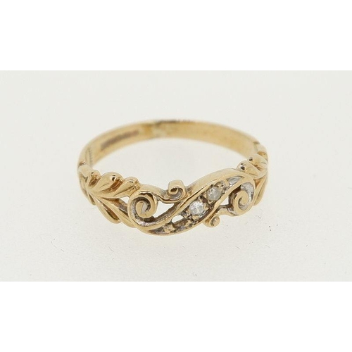 456 - A 9 carat gold ring crossover set three diamonds, one deficient, decorated pierced surround, 1.4g, s... 