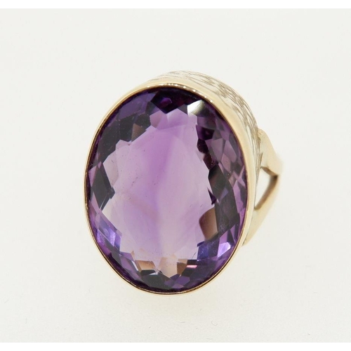 458 - A 9 carat gold handmade large oval cut Brazilian amethyst ring with deep engraved band setting made ... 