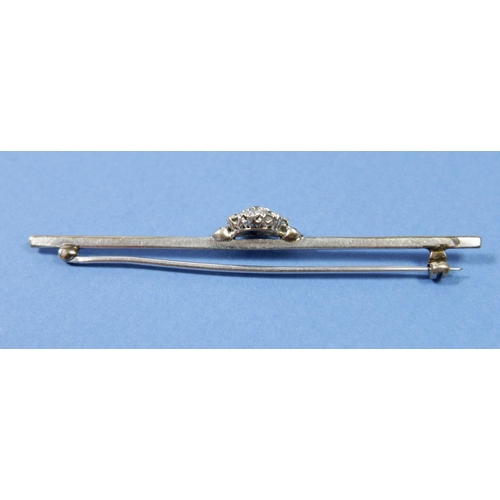 494 - A diamond cluster bar brooch set in platinum or white gold, bar 7cm long, 3.8g