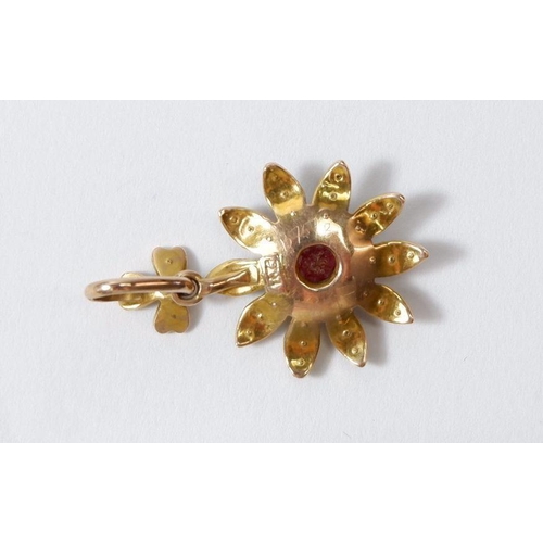 514 - An Edwardian 9 carat gold floral pendant set red stone to centre and seed pearls to petals, 1.5cm di... 