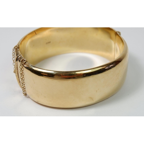 540 - A 9ct gold hinged and engraved bangle, 33gm