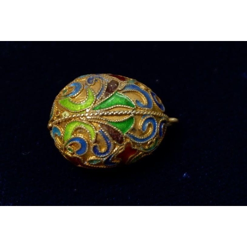 551 - A Russian style enamel miniature egg form pendant or charm with crucifix and scrollwork decoration, ... 