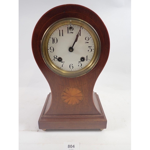 804 - An Edwardian mahogany balloon form clock with satinwood paterae, 31cm, with key and pendulum