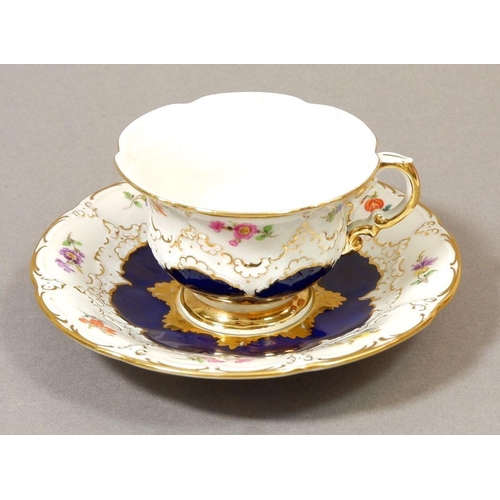 139 - A 20th century Meissen cabinet cup and saucer painted flower with blue and gilt borders, crossed swo... 