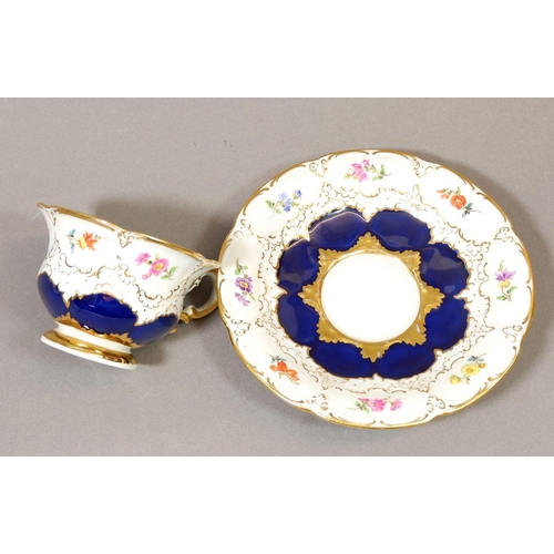 139 - A 20th century Meissen cabinet cup and saucer painted flower with blue and gilt borders, crossed swo... 