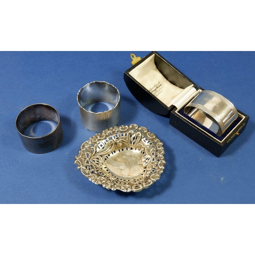 299 - Three silver napkin rings 128g, one boxed and a silver pierced trinket dish, Chester 1898, 21g