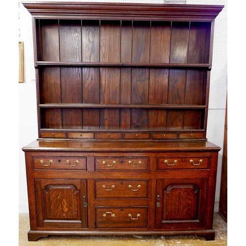 1023 - A part Georgian oak dresser with later back, the base with three frieze drawers over two cupboards a... 