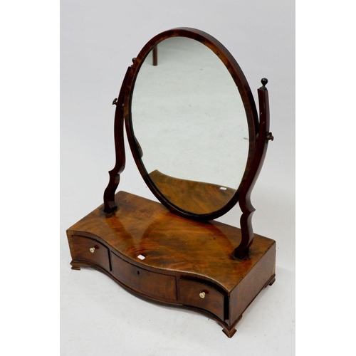 1024 - A Georgian mahogany oval swing mirror on serpentine base with three drawers, 44cm wide