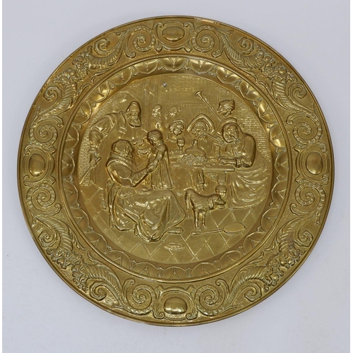 1029 - A large brass circular plaque embossed tavern scene, 72cm diameter